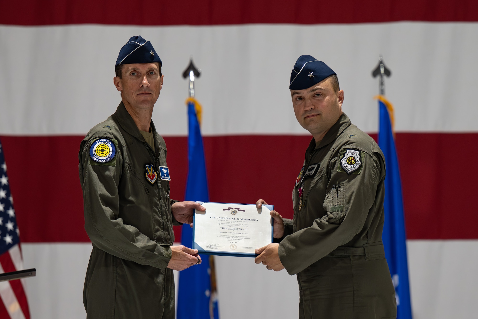 Brig. Gen. Lawrence Sullivan, outgoing 57th Wing commander, is presented the Legion of Merit award by Maj. Gen. David Epperson, left, U.S. Air Force Warfare Center commander, during a change of command ceremony at Nellis Air Force Base, Nevada, June 15, 2026.