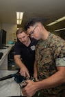 U.S. Marine Corps Lance Cpl. Joseph Lussier, right, a ground electronics telecommunications and information technology systems maintainer with 3rd maintenance battalion, Combat Logistics Regiment 35, 3rd Marine Logistics Group, is instructed on AN/PRC-160 radio testing by Cody Payne, an engineering technician with L3 Harris, during radio repair and servicing training on Camp Kinser, Okinawa, Japan, June 4, 2026. Marines received hands-on training from L3Harris technicians through a partnership with the operations and sustainment company V2X in efforts to improve servicing and repair capabilities within 3rd MLG. (U.S. Marine Corps photo by Lance Cpl. Marcus Henson)