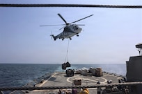 A Eurocopter AS565 Panther helicopter, attached to Lewis and Clark-class dry cargo ship USNS Carl Brashear (T-AKE-47), delivers supplies on the flight deck of Arleigh Burke-class guided-missile destroyer USS McFaul (DDG 74) during a vertical replenishment in support of Operation Epic Fury, March 19, 2026. (U.S. Navy photo)