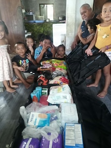 Airman's family posing with supplies.