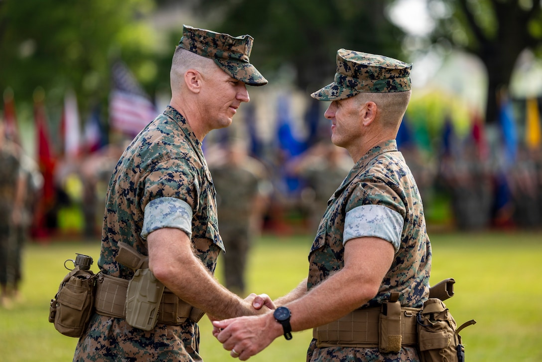 U.S. Marine Corps Lt. Col. Christopher Schaub, left, the oncoming commanding officer of II Marine Expeditionary Force Support Battalion, shakes hands with Lt. Col. Spencer Sweet, the offgoing commanding officer of II MSB, during a change of command ceremony at Marine Corps Base Camp Lejeune, North Carolina, June 15, 2026. The change of command ceremony symbolizes the passing of authority and responsibility from the offgoing to the oncoming commanding officer. (U.S. Marine Corps photo by Pfc. John Allen)