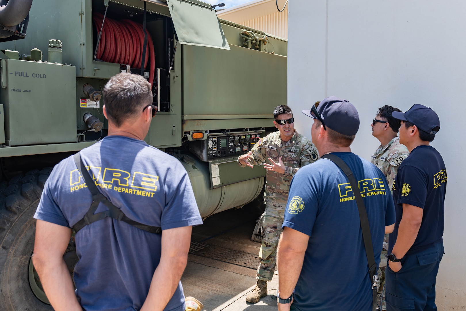U.S. Army Staff Sgt. John Segawa, center, a station chief assigned to the 297th Engineer Detachment Firefighting Team, 103D Troop Command, Hawaii Army National Guard, explains his equipment and capabilities to the Honolulu Fire Department in Nanakuli, Hawaii, Aug. 1, 2025.
