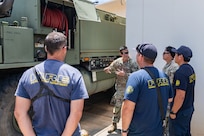 U.S. Army Staff Sgt. John Segawa, center, a station chief assigned to the 297th Engineer Detachment Firefighting Team, 103D Troop Command, Hawaii Army National Guard, explains his equipment and capabilities to the Honolulu Fire Department in Nanakuli, Hawaii, Aug. 1, 2025.