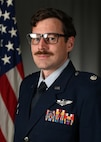 photo of US Air Force Airman standing in front of a US flag