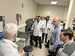 scientists and logisticians observe sword in testing equipment