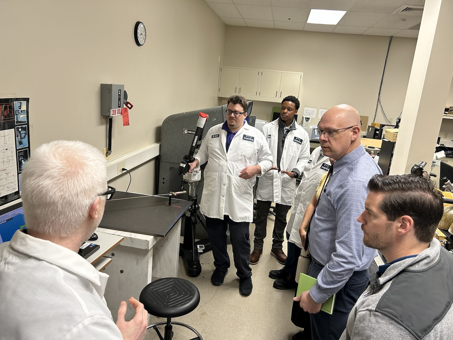 scientists and logisticians observe sword in testing equipment