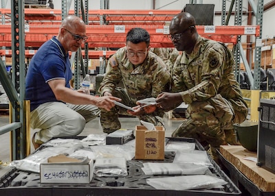 Alvin Rodriguez a program manager with DLA Disposition Services at Battle Creek, Michigan, instructs Army reservist Staff Sgt. Yahua Chen and Sgt. 1st Class Destiny Ogbeni on warehouse operations during Joint Contingency Operational Readiness Training.