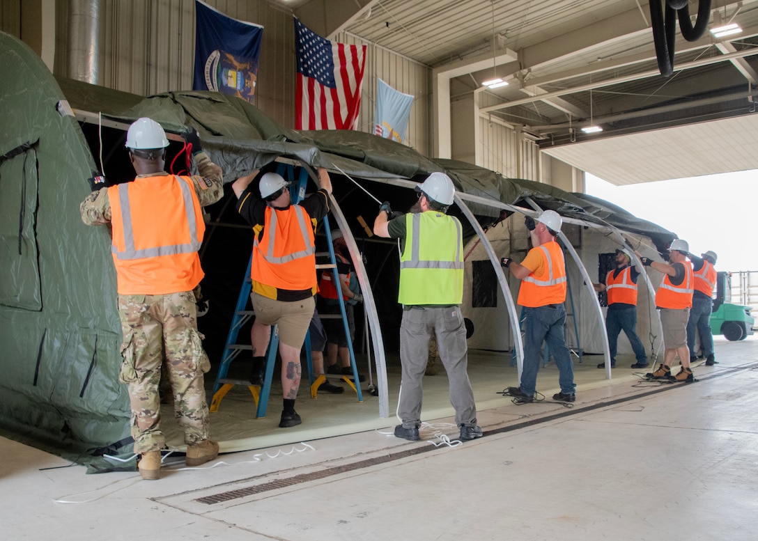 Military and DLA Civilian Members of the Contingency Overseas Readiness Exercise team construct an Alaska Small Shelter at their exercise site in Battle Creek, Michigan.