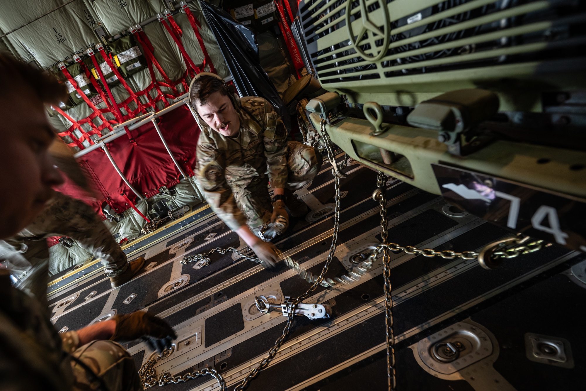 U.S. Air Force Staff Sgt. Thomas Kile, a power production specialist with the 123rd Airlift Wing, Kentucky Air National Guard, chains a Danish Armed Forces vehicle to the floor of a U.S. Air Force C-130J Super Hercules aircraft at Karup Air Base, Denmark, in preparation for airlift to Norway during a search-and-recovery training scenario June 9, 2026. The 123rd AW is providing tactical airlift to NATO Allies throughout the month of June in support of Ramstein Flag 2026, an Allied Air Command large-scale, multi-location and joint operating area exercise with 18 participating nations and more than 200 aircraft. (U.S. Air National Guard photo by Lt. Col. Dale Greer)
