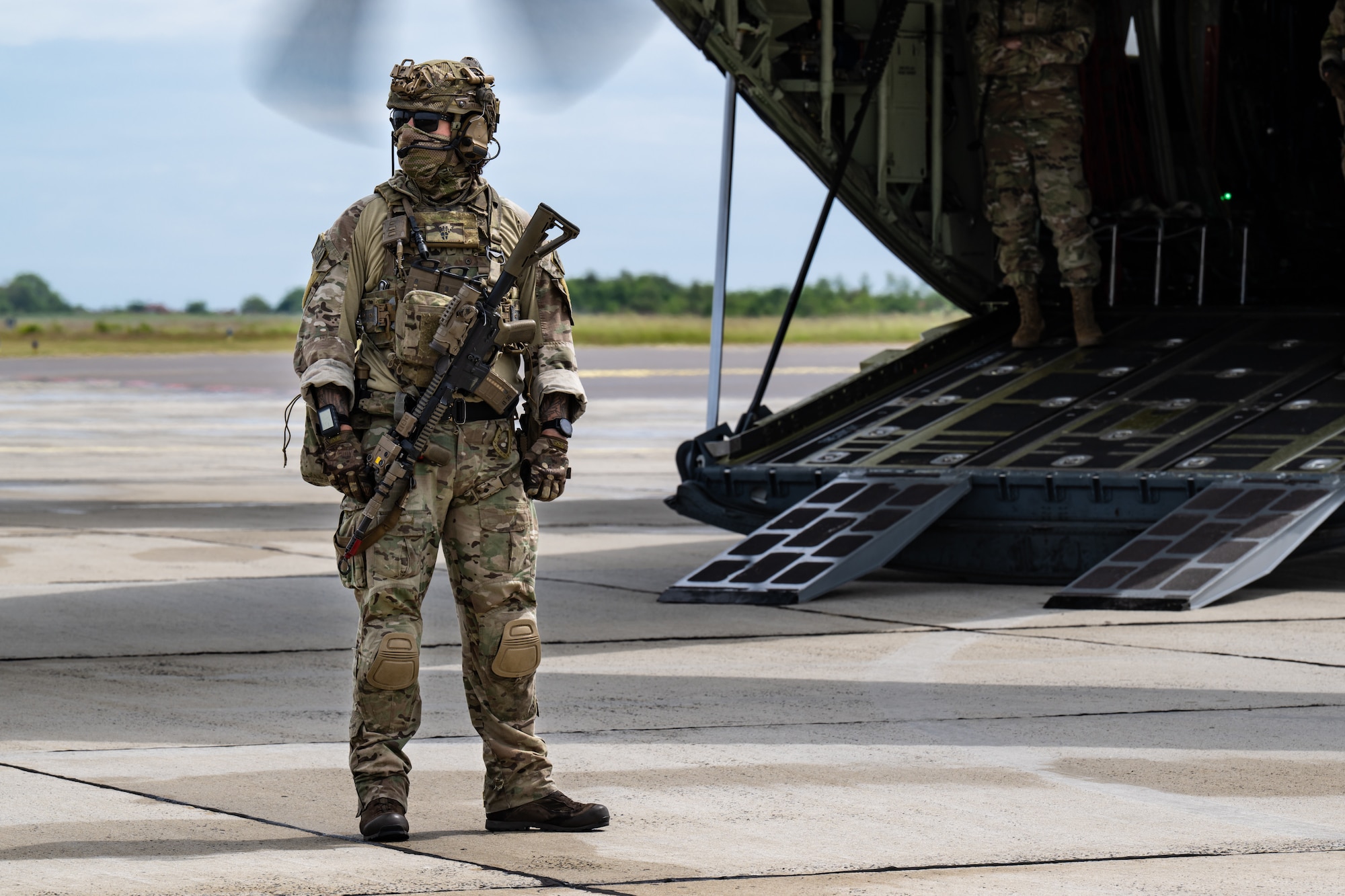A member of the Danish Armed Forces provides perimeter security for a U.S. Air Force C-130J Super Hercules aircraft assigned to the 123rd Airlift Wing, Kentucky Air National Guard, during a search-and-recovery training scenario at Bornholm Airport near Rønne, Denmark, June 9, 2026. The 123rd AW is providing tactical airlift to NATO Allies throughout the month of June in support of Ramstein Flag 2026, an Allied Air Command large-scale, multi-location and joint operating area exercise with 18 participating nations and more than 200 aircraft. (U.S. Air National Guard photo by Lt. Col. Dale Greer)