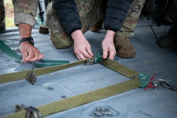 A soldier inspects contents of a backpack.