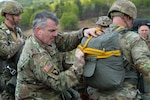 An Army soldier inspects a backpack on another soldier.