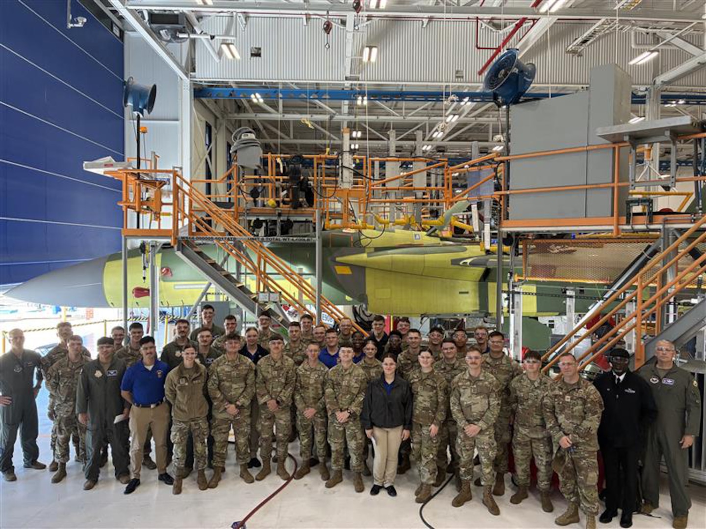 A group of military personnel stand in front of an aircraft