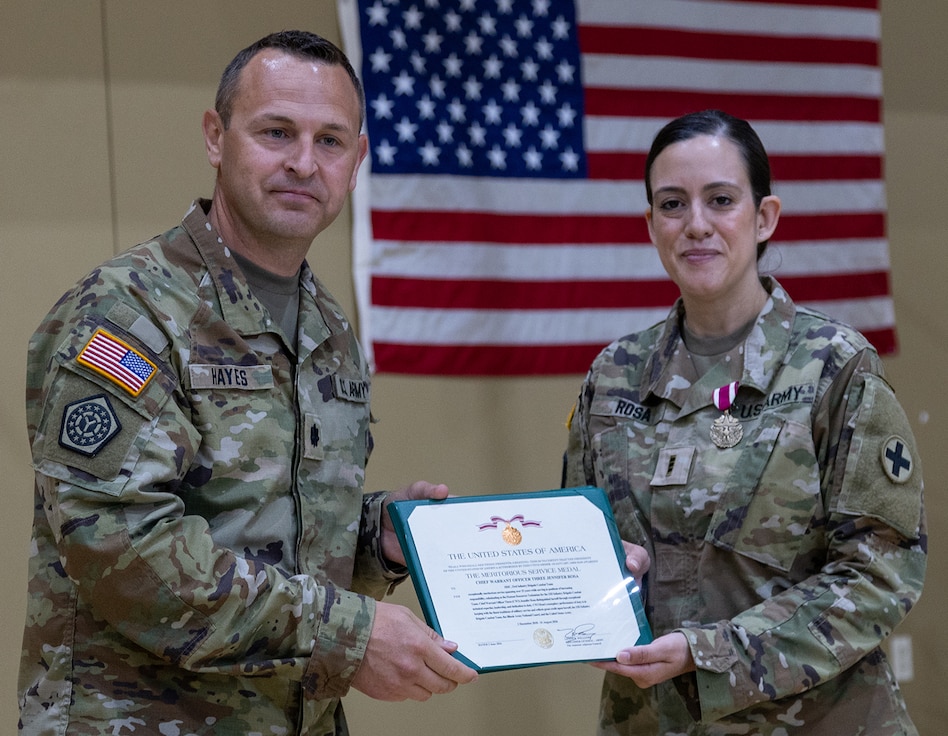 Lt. Col. Russell Hayes, 33rd Infantry Brigade Combat Team executive officer, presents Chief Warrant Officer 3 Jennifer Rosa with the Meritorious Service Medal during a retirement ceremony June 5 at the brigade headquarters in Urbana.