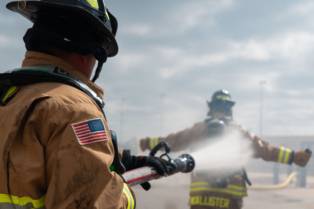 U.S. Air Force firefighters wash off after an emergency response exercise at the Louis F. Garland Department of War Fire Academy, Goodfellow Air Force Base, Texas, June 10, 2026.
