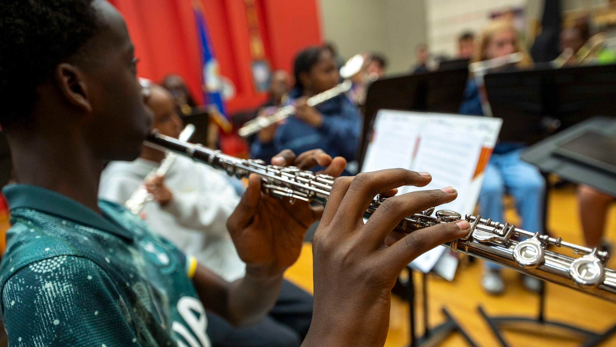 A student holds a flute while playing.