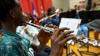 A student holds a flute while playing.