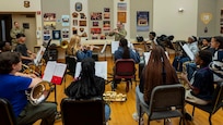 An Airman conducts a student wind ensemble.