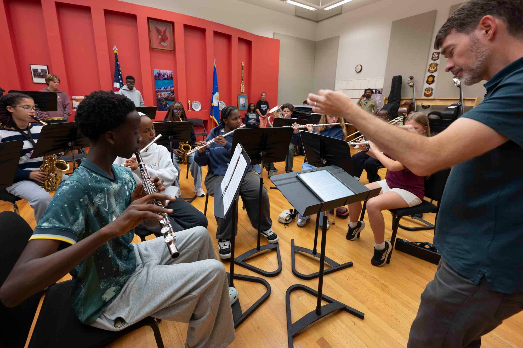 A man conducts students playing wind instruments.