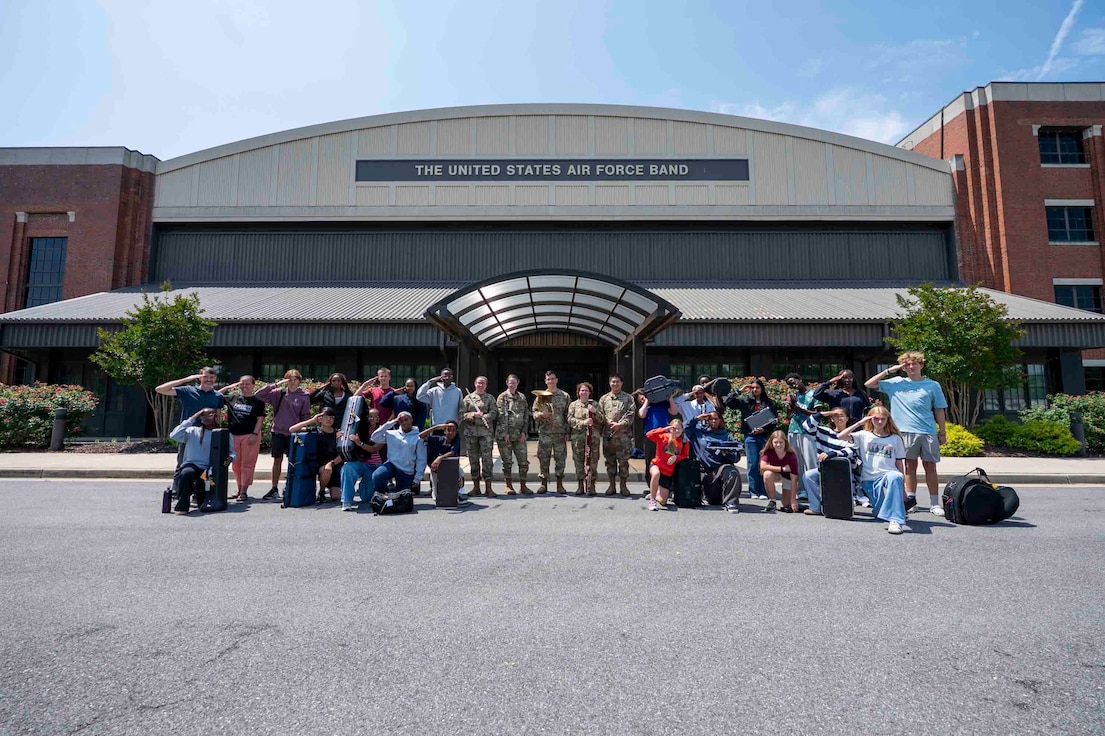 Students pose with Airmen in front of the USAF Band building.