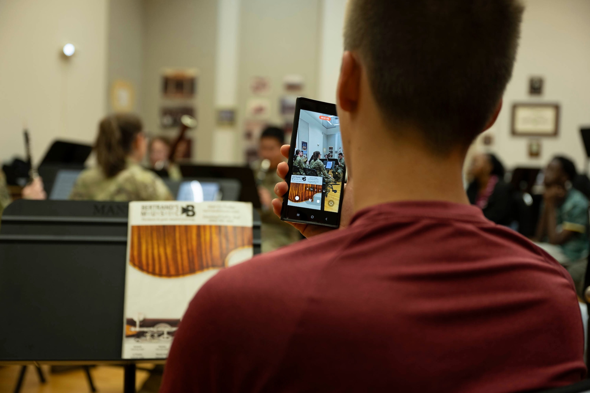 A student films the band with a phone.