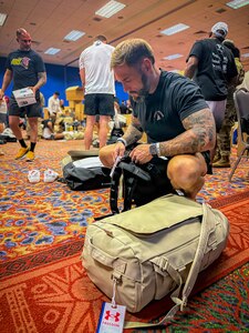 Chief Warrant Officer 3 Jon Tallman organizes his gear and equipment bags during the Team Army uniform distribution event In San Antonio, Texas, June 10, 2026.