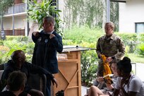 Dr. Tyler Bennett (left), Army Recovery Care Program Director, receives Team Army paraphernalia from Maj. Casey Turner (right),