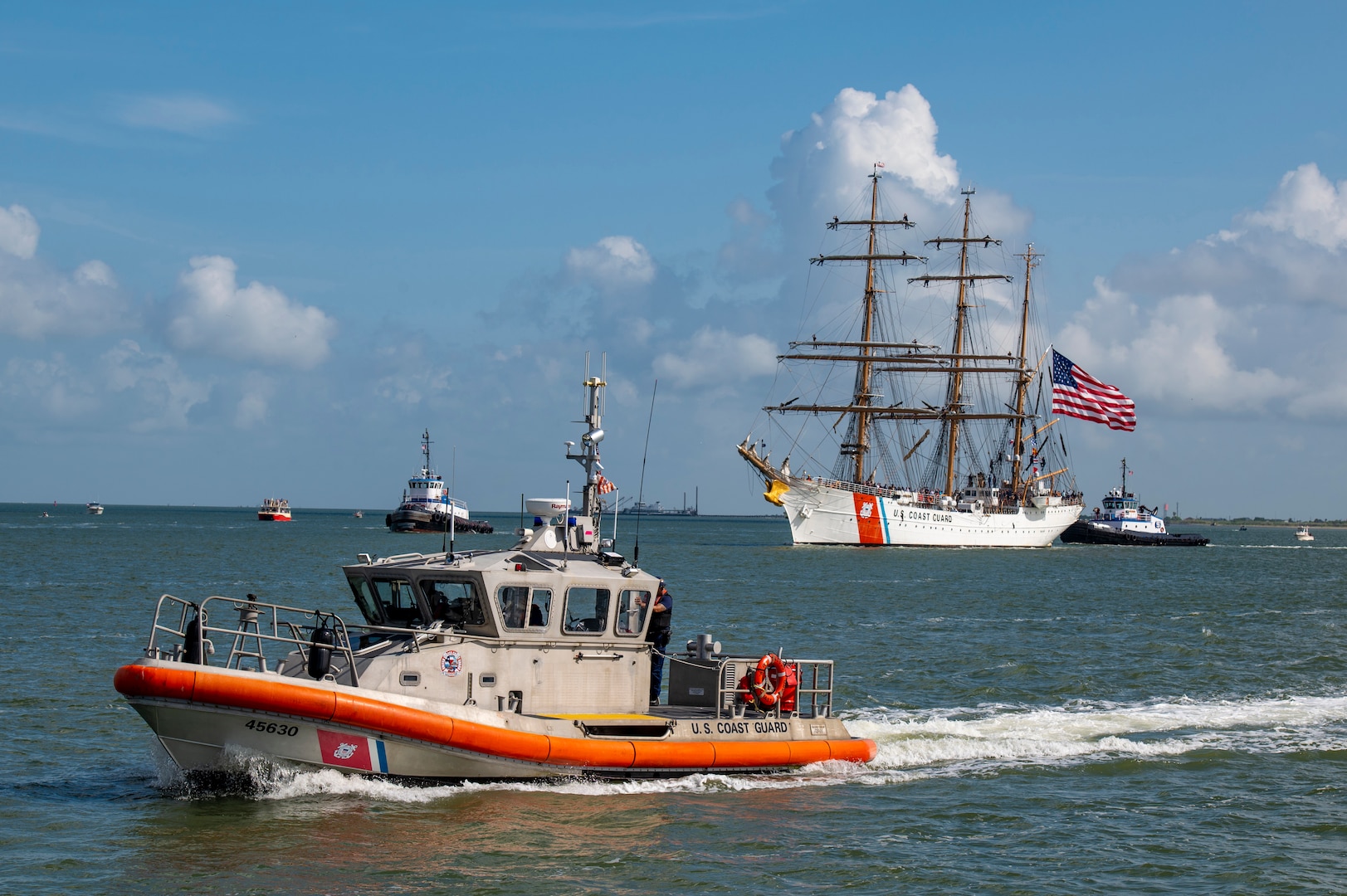 A Coast Guard Station Galveston 45-foot Response Boat-Medium provides security as the U.S. Coast Guard Cutter Barque Eagle transits the Galveston Channel towards Pier 21 in Galveston, Texas, June 10, 2022. Homeported at the Coast Guard Academy in New London, Conn., the Eagle is used as a training platform for future Coast Guard officers and visited Galveston, Texas, for the first time since 1972. (U.S. Coast Guard photo by Petty Officer 2nd Class Ryan Dickinson)