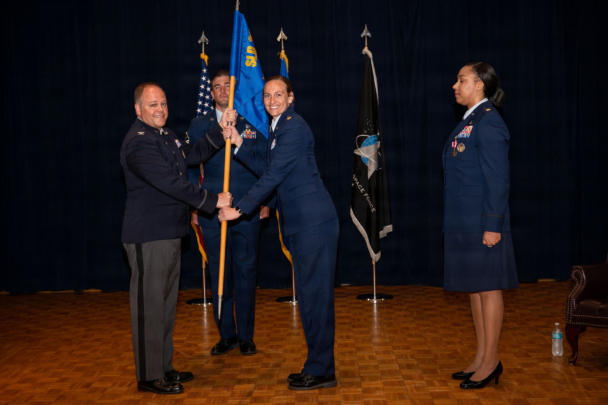 a person hands a guidon to another person
