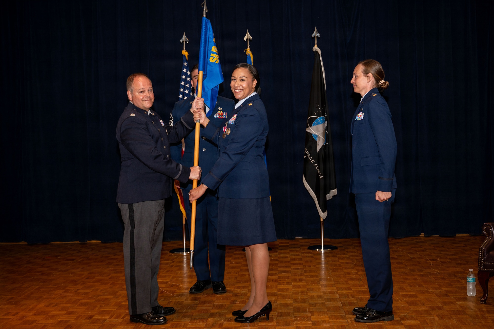 a person hands a guidon to another person
