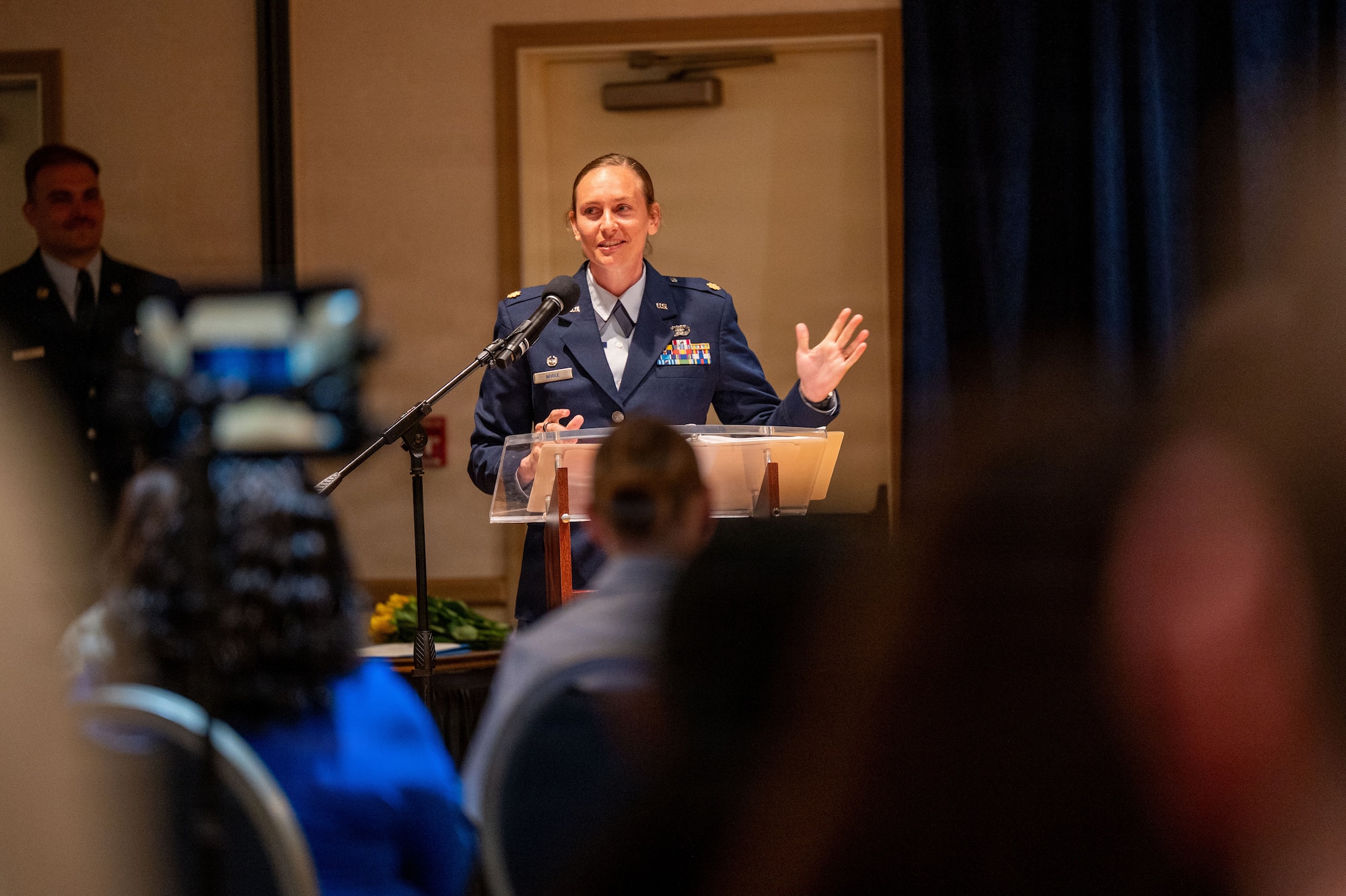 a person stands at a podium and speaks to a crowd