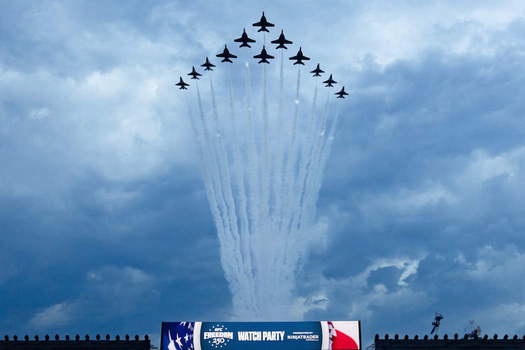 Military aircraft fly over UFC Freedom 250 event.
