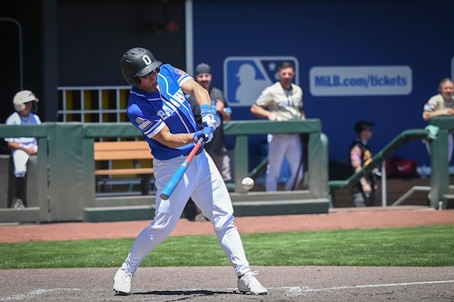 An action shot of a Hill Air Force Base baseball player in mid-swing at home plate.