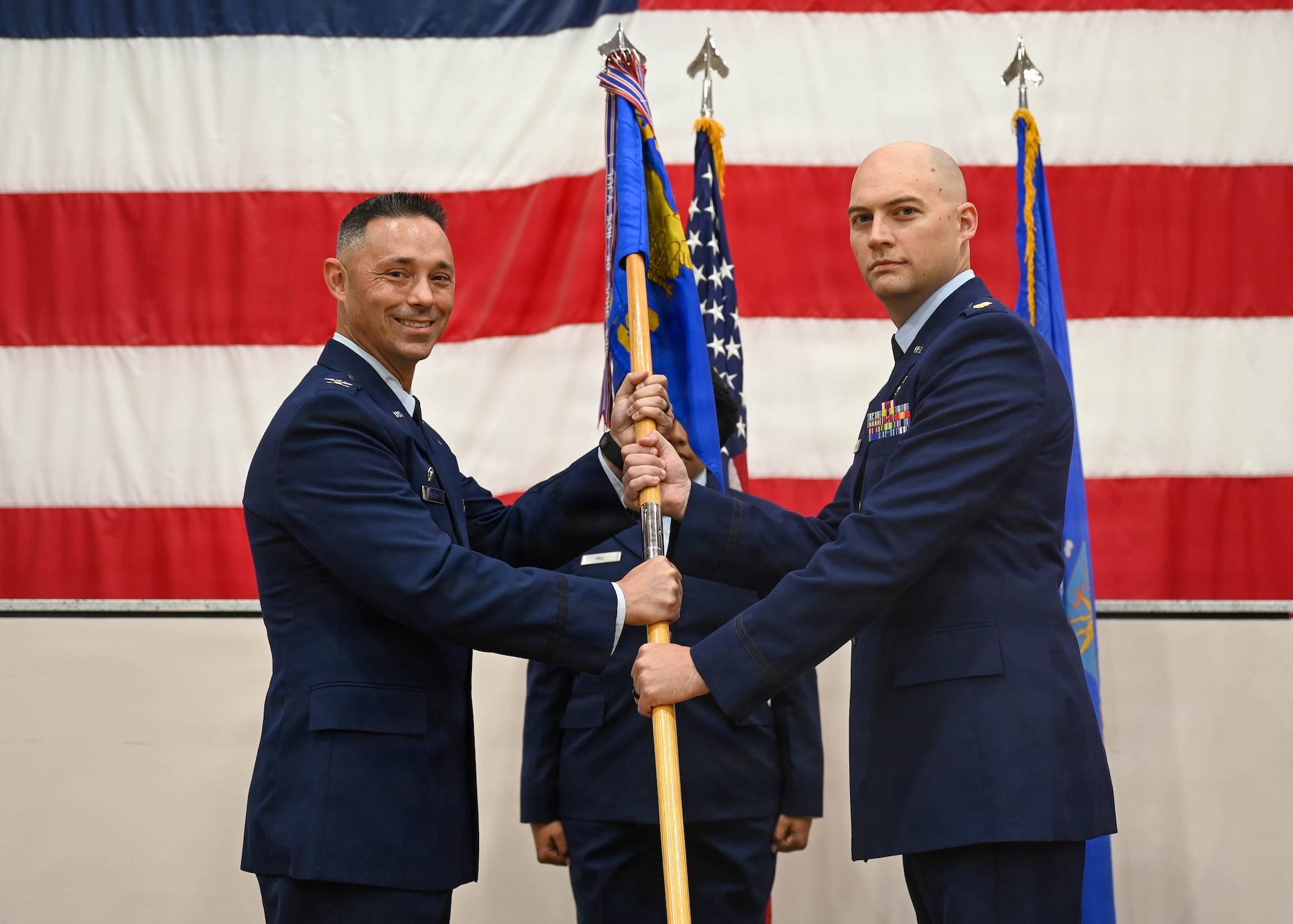 U.S. Air Force Col. Darryl Hebert, 56th Mission Support Group commander, passes the guidon to Maj. Justin Clarke, incoming 56th Communications Squadron commander, at Luke Air Force Base, Arizona, June 16, 2026