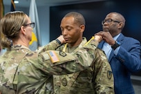 Maj. Terrell Murdock, U.S. Army Financial Management Command Army banking officer and executive officer, receives a Maj. Gen. Nathan Towson Regimental Medallion from Col. Michelle M. Williams, USAFMCOM commander, left, and retired Command Sgt. Maj. Gennaro Penn, Finance Corps Association president at the Maj. Gen. Emmett J. Bean Federal Center in Indianapolis June 15, 2026. The Towson Medallion was established by the U.S. Army Finance Corps Association on May 7, 1993, to recognize exceptional achievement or exemplary service by currently serving U.S. Army finance and comptroller commissioned officers, non-commissioned officers, enlisted Soldiers and civilians demonstrating exceptional leadership and whose accomplishments clearly distinguish them from their peers. (U.S. Army photo by Mark R. W. Orders-Woempner) (U.S. Army photo by Mark R. W. Orders-Woempner)
