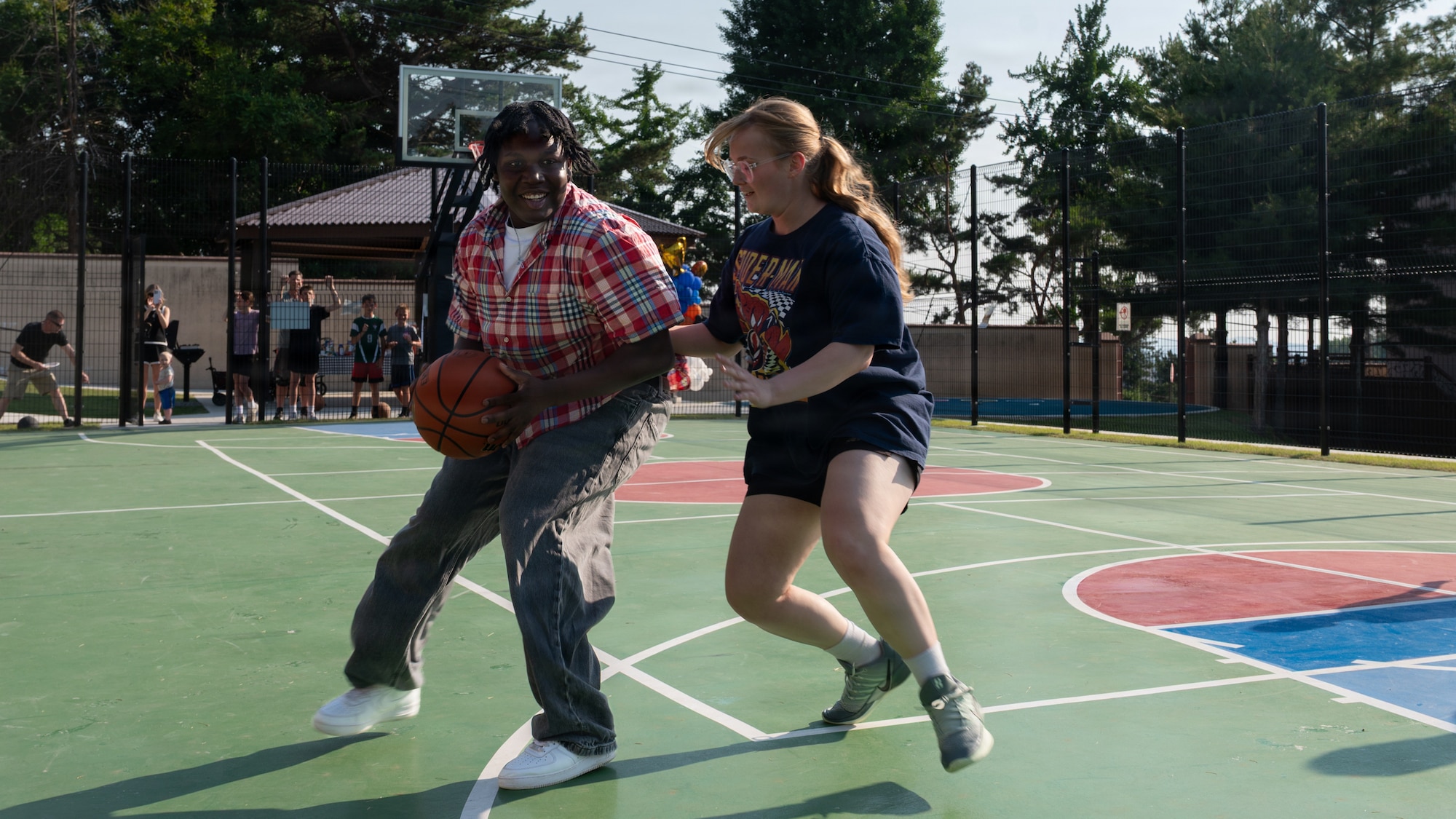Two students play basketball.