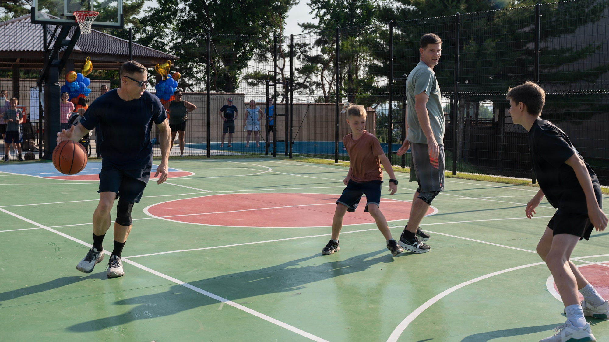 Parents and their kids play basketball.