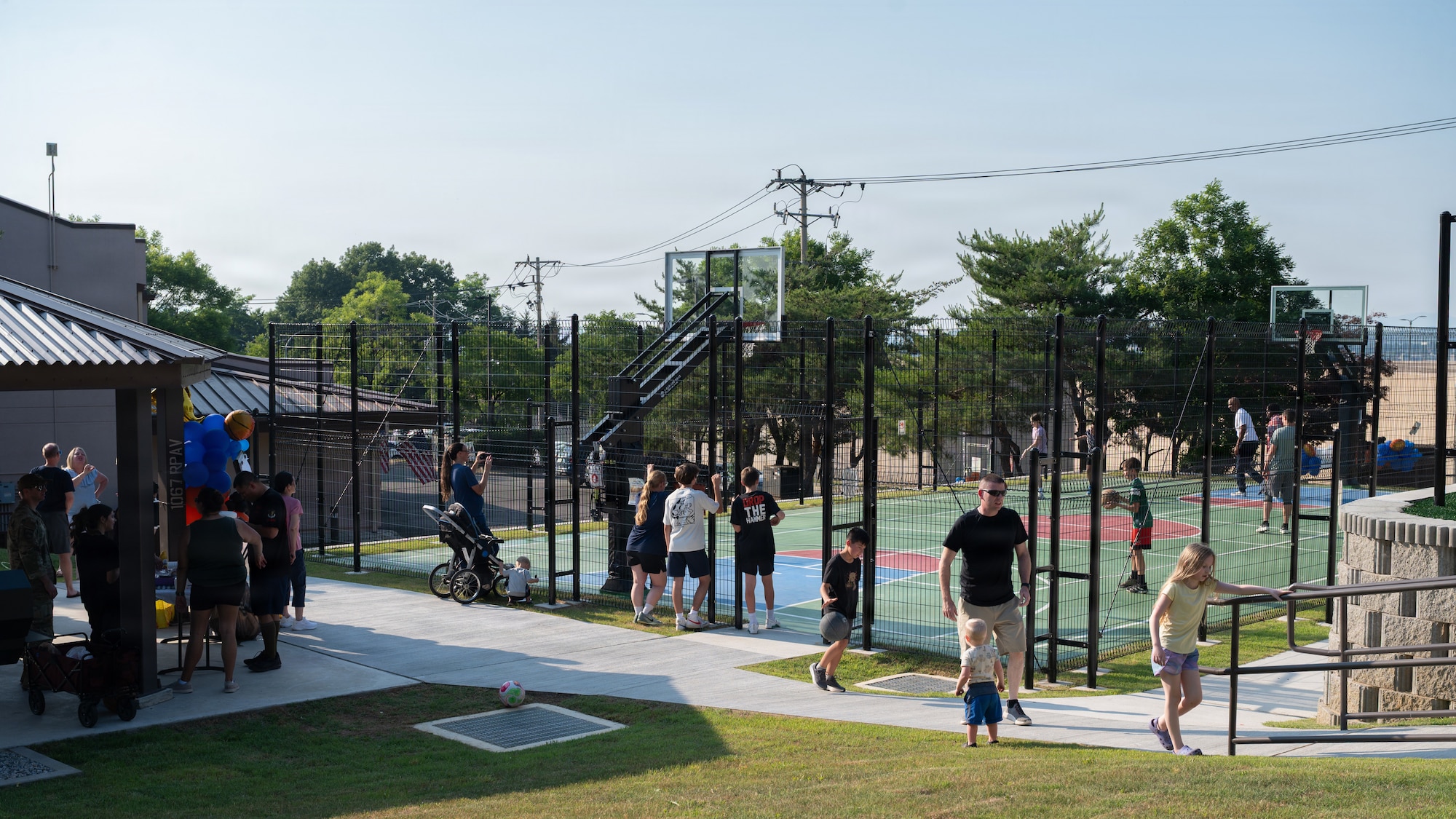 People hanging around a basketball court.