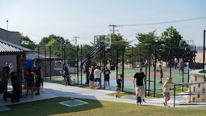 People hanging around a basketball court.