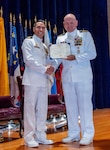 Naval Base Ventura County, Calif. (May 21, 2026) Capt. Aaron Peterson, director of Training, Tactical Development, Ordnance, and Doctrine for Commander, Submarine Force, U.S. Pacific Fleet, right, presents Cmdr. Andrew Lichtenstein, outgoing commanding officer of Unmanned Undersea Vehicle Squadron (UUVRON) 3, his end-of-tour award during the change of command ceremony at Needham Theater at Naval Base Port Hueneme, May 21, 2026. UUVRON 3’s mission is to tactically operate and maintain XLUUVs fleetwide. (U.S. Navy photo by Lt. Nicholas Wade)