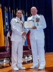 Naval Base Ventura County, Calif. (May 21, 2026) Capt. Aaron Peterson, director of Training, Tactical Development, Ordnance, and Doctrine for Commander, Submarine Force, U.S. Pacific Fleet, right, presents Cmdr. Andrew Lichtenstein, outgoing commanding officer of Unmanned Undersea Vehicle Squadron (UUVRON) 3, his end-of-tour award during the change of command ceremony at Needham Theater at Naval Base Port Hueneme, May 21, 2026. UUVRON 3’s mission is to tactically operate and maintain XLUUVs fleetwide. (U.S. Navy photo by Lt. Nicholas Wade)