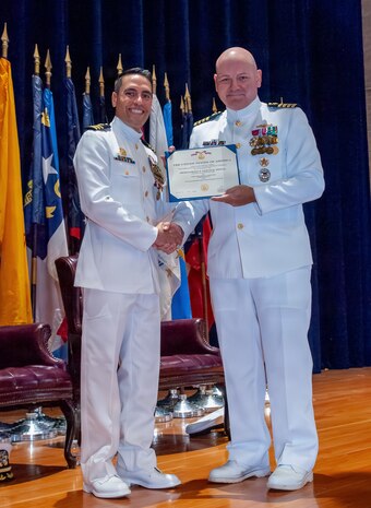 Naval Base Ventura County, Calif. (May 21, 2026) Capt. Aaron Peterson, director of Training, Tactical Development, Ordnance, and Doctrine for Commander, Submarine Force, U.S. Pacific Fleet, right, presents Cmdr. Andrew Lichtenstein, outgoing commanding officer of Unmanned Undersea Vehicle Squadron (UUVRON) 3, his end-of-tour award during the change of command ceremony at Needham Theater at Naval Base Port Hueneme, May 21, 2026. UUVRON 3’s mission is to tactically operate and maintain XLUUVs fleetwide. (U.S. Navy photo by Lt. Nicholas Wade)