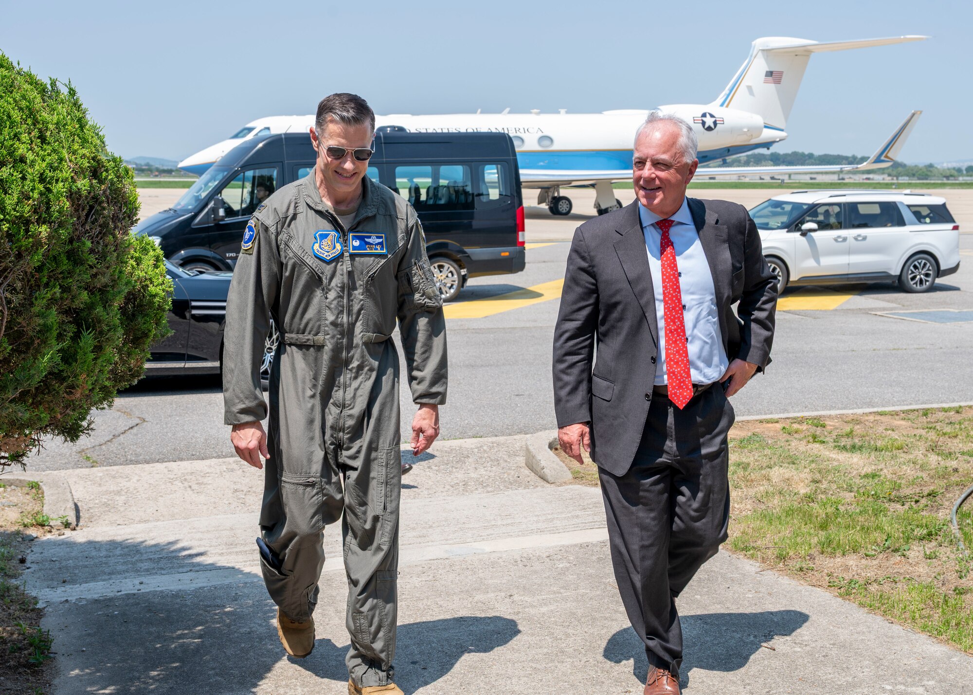 Two people walk off a flightline