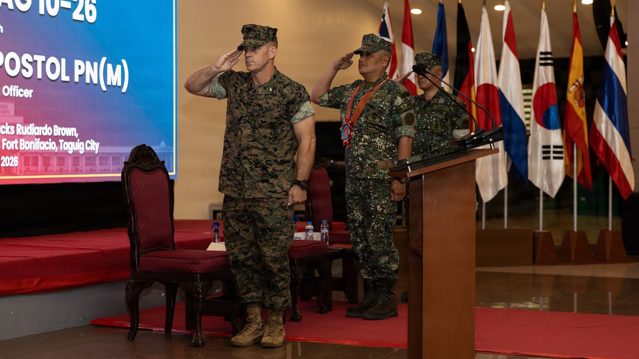 U.S. Marine Corps Col. George J. Flynn, left, commanding officer of Marine Rotational Force – Darwin, I Marine Expeditionary Force, Philippine Marine Corps Brig. Gen. Bob R. Apostol, director of Exercise Directorate Headquarters, and PMC Col. Edwin Jospeh H. Olaer, assistant director of EDH, salute during the playing of the American national anthem as part of the KAMANDAG 10 opening ceremony on Fort Bonifacio, Philippines, June 15, 2026.
