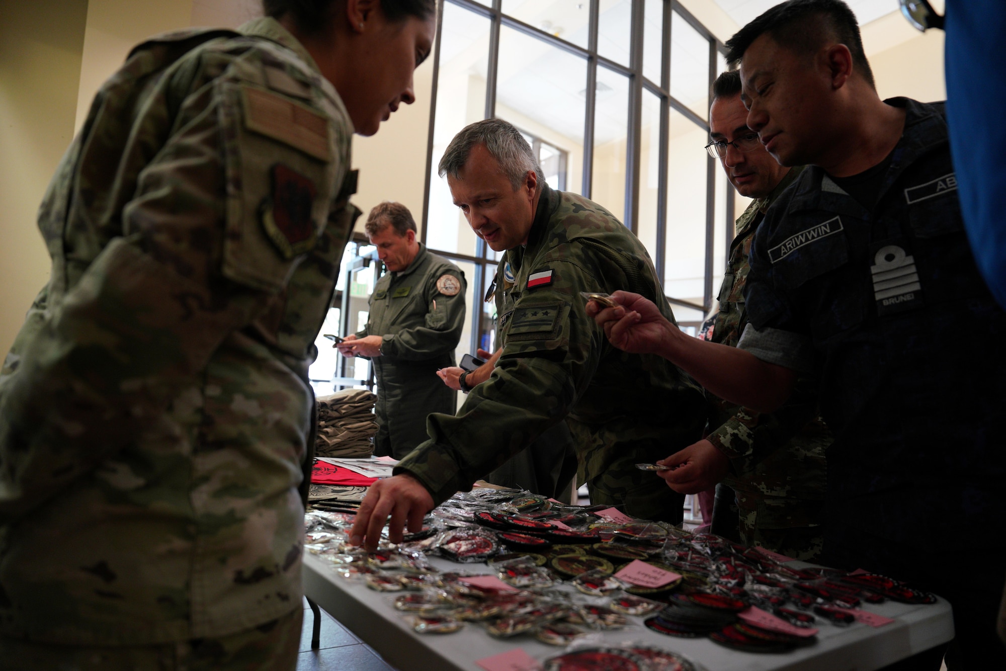 Members of the International Air and Space Attachés browse heritage patches during an orientation tour at Creech Air Force Base, Nevada, June 12, 2026. Attaché tours are essential in maintaining strong relationships and readiness between allies and partners. (U.S. Air Force photo by Airman Vinh Phan)