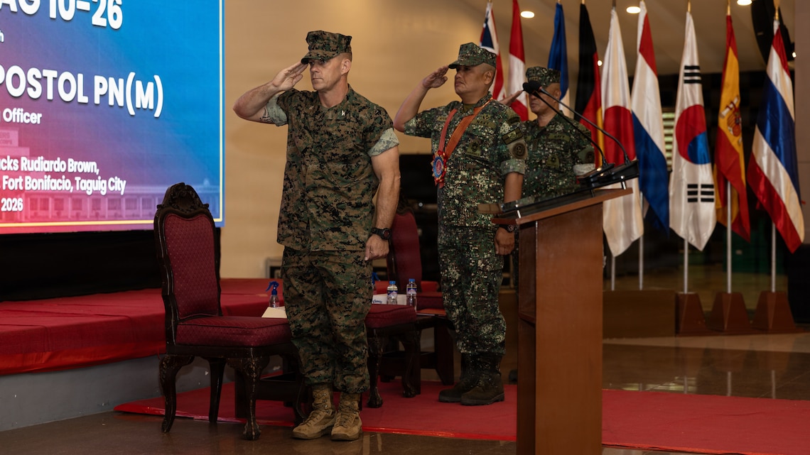 U.S. Marine Corps Col. George J. Flynn, left, commanding officer of Marine Rotational Force – Darwin, I Marine Expeditionary Force, Philippine Marine Corps Brig. Gen. Bob R. Apostol, director of Exercise Directorate Headquarters, and PMC Col. Edwin Jospeh H. Olaer, assistant director of EDH, salute during the playing of the American national anthem as part of the KAMANDAG 10 opening ceremony on Fort Bonifacio, Philippines, June 15, 2026.