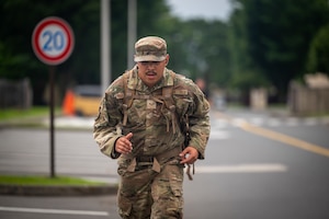 An Airman wearing a uniform runs down a street.