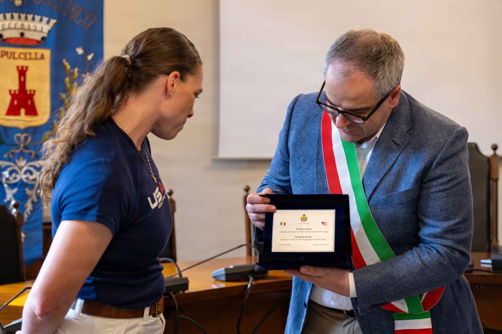 A man presents a woman with a plaque