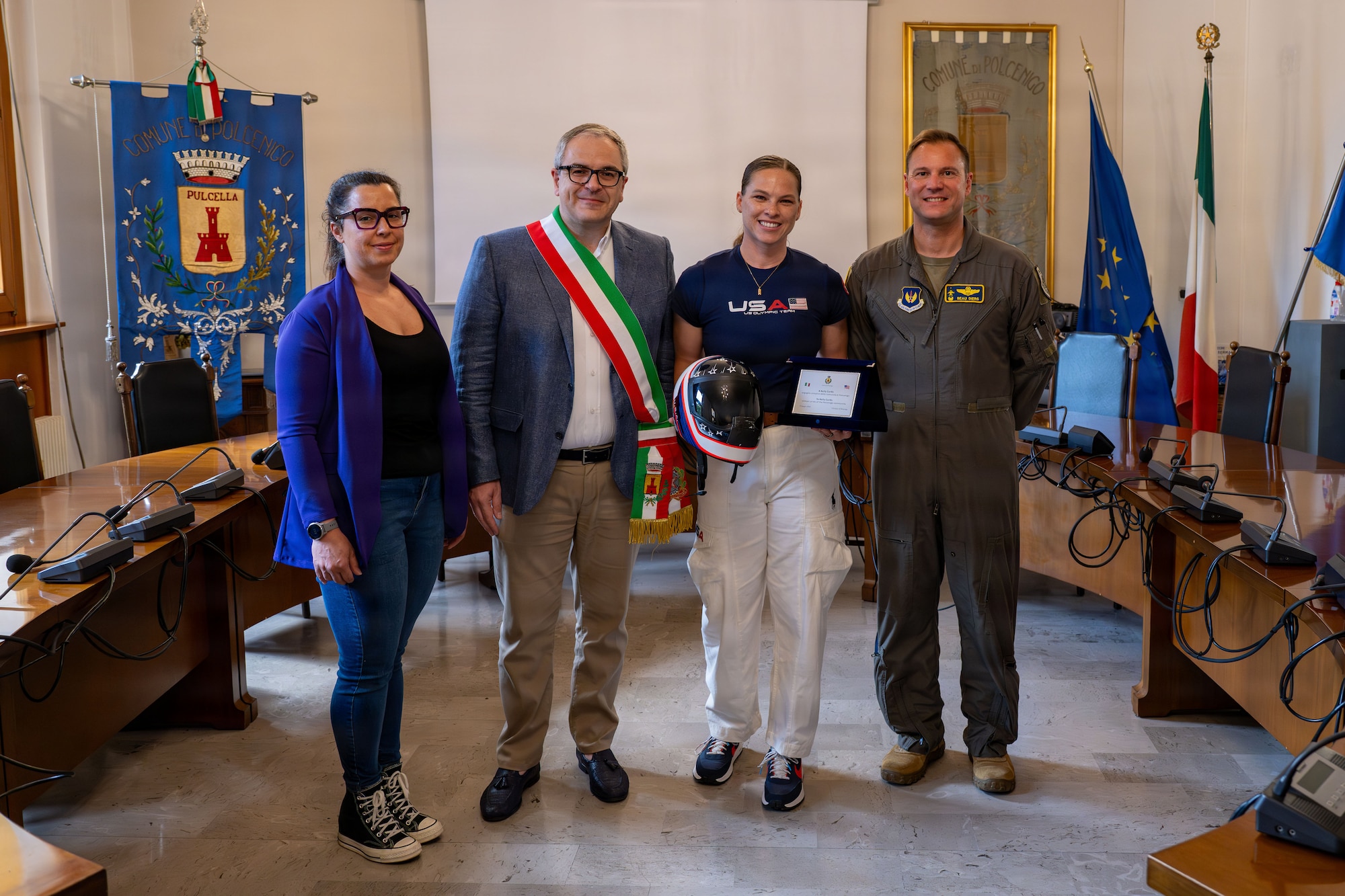 People pose for a photo with a plaque