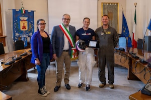 People pose for a photo with a plaque